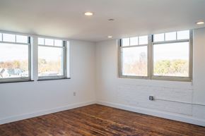 Hartford apartment for rent - A room with white walls and wooden floors with two windows.