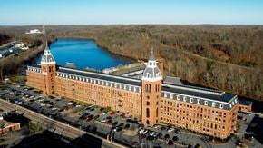 Taftville apartment for rent - an aerial view of a large building next to a river at Ponemah Mills in Taftville, CT, 06380