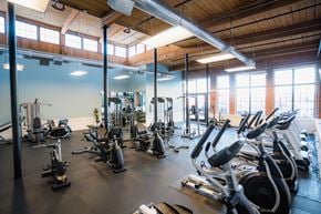 Taftville apartment for rent - a gym with a lot of exercise equipment and windows at Ponemah Mills in Taftville, CT, 06380