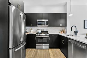 Farmington apartment for rent - A modern kitchen with black cabinets and stainless steel appliances.
