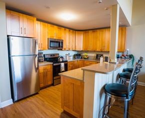 Taftville apartment for rent - a kitchen with wooden cabinets and stainless steel appliances at Ponemah Mills in Taftville, CT, 06380