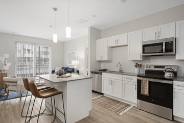 Biddeford apartment for rent - A modern kitchen with white cabinets and a large island.