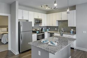 Scarborough apartment for rent - a kitchen with granite counter top and stainless steel refrigerator at The Beacon at Gateway Apartments, Scarborough, ME, 04074