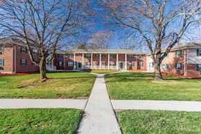 Glastonbury apartment for rent - Sidewalk in front of a brick building with trees at Griswold Gardens in Glastonbury, CT, 06033