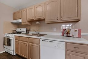 Carol Stream apartment for rent - a kitchen with white appliances and wooden cabinets at St Charles Square Apartments, Carol Stream