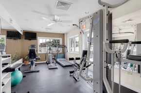 Carol Stream apartment for rent - a gym with weights and cardio equipment and a window at St Charles Square Apartments, Carol Stream