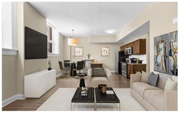 Hartford apartment for rent - A living room with a white sofa, a black coffee table, and a television on the wall.
