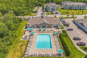 Scarborough apartment for rent - a aerial view of a swimming pool and a house with umbrellas at The Beacon at Gateway Apartments, Scarborough, ME, 04074