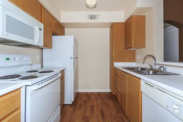 Pittsburg apartment for rent - A kitchen with white appliances and wooden cabinets.