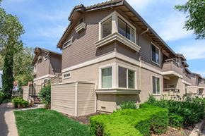 Pittsburg apartment for rent - A beige house with a brown roof and a green lawn in front.