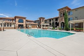 Pittsburg apartment for rent - A large swimming pool in front of a building with a clear blue sky.