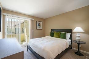 Pittsburg apartment for rent - A bedroom with a large bed and a lamp on a side table.