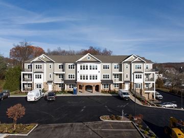 Warren apartment for rent - A large white building with a parking lot in front.