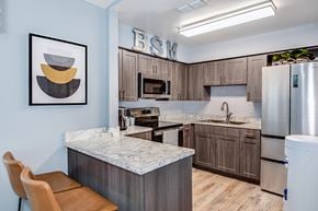 Brandon apartment for rent - View of Brookside Manor's renovated and redecorated clubhouse kitchen and bar with wood laminate flooring and stainless steel appliances