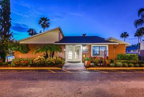 Tampa apartment for rent - Park Avenue Apartments Tampa Florida Clubhouse Exterior with Trees and Blue Glowing Sky in Background