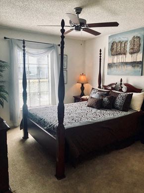 Brandon apartment for rent - a bedroom with a four poster bed and a ceiling fan