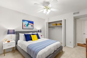 Metairie apartment for rent - A bedroom with a bed, a ceiling fan, and a painting on the wall.