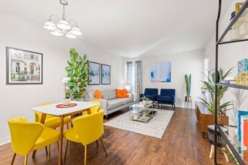 Metairie apartment for rent - A living room with a white table and yellow chairs.