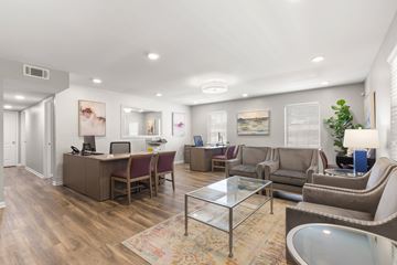 Metairie apartment for rent - A spacious living room with a glass coffee table and a variety of seating options.