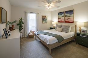 River Ridge apartment for rent - A bedroom with a large bed and a ceiling fan.