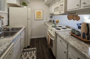 River Ridge apartment for rent - A kitchen with a white fridge, white cabinets, and a white microwave.