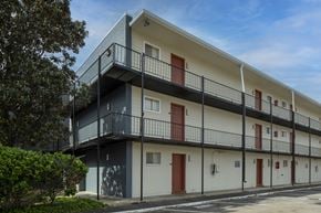 Metairie apartment for rent - A modern apartment building with balconies and red doors.