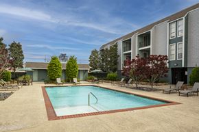 Metairie apartment for rent - A swimming pool surrounded by a red brick border in a residential area.