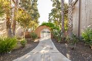 Visalia apartment for rent - A garden pathway leads to a brick archway.