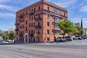 El Paso apartment for rent - A red brick building with a yellow door and balconies.