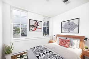 El Paso apartment for rent - A bedroom with a bed, two pillows, a nightstand, and two framed pictures on the wall.