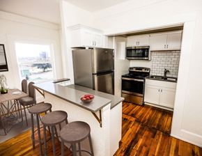 El Paso apartment for rent - A kitchen with a refrigerator, stove, and bar stools.