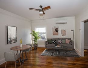 El Paso apartment for rent - A living room with a grey couch, a round table, and a ceiling fan.