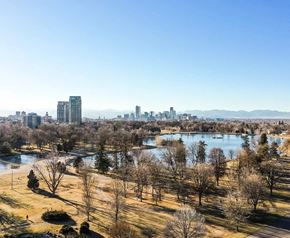 Denver apartment for rent - A cityscape with a large lake and trees in the foreground.