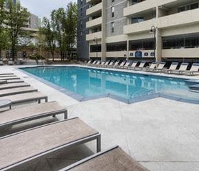 Denver apartment for rent - a large swimming pool with benches and a building