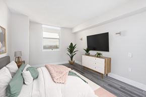 Denver apartment for rent - a bedroom with a bed and a tv on the wall