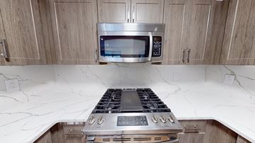 Philadelphia apartment for rent - A modern kitchen with a stove top oven and microwave above it.