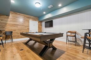 Cary townhouse for rent - A pool table is in the middle of a room with a wooden floor and a white door.