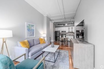 Nashville apartment for rent - A modern living room with a grey couch and a grey rug.