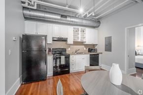 Nashville apartment for rent - A black refrigerator is in a white kitchen with wooden floors.