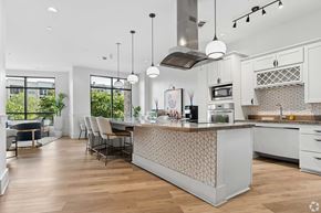 Cary apartment for rent - A modern kitchen with a large island and pendant lights.