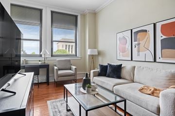 Nashville apartment for rent - A living room with a grey couch, a glass coffee table, and a painting on the wall.