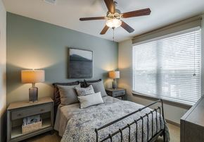 Charleston apartment for rent - A bedroom with a bed, two lamps, and a ceiling fan.