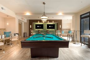 Charleston apartment for rent - A pool table in a room with a light brown floor.