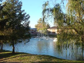 Indianapolis apartment for rent - a fountain in a lake with a building in the background