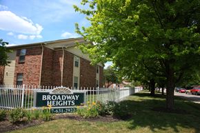 Indianapolis apartment for rent - a building with a broadway heights sign in front of a white fence