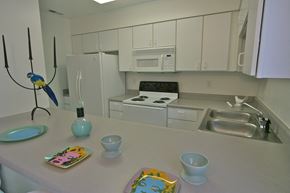 Indianapolis apartment for rent - a view of a kitchen with white cabinets and appliances and a counter top with dishes