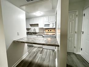 Indianapolis apartment for rent - A kitchen with a marble countertop and white cabinets.