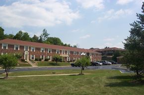 Centerville apartment for rent - a large brick building with cars parked in a parking lot