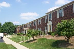 Centerville apartment for rent - an exterior view of a brick building with lawn and trees