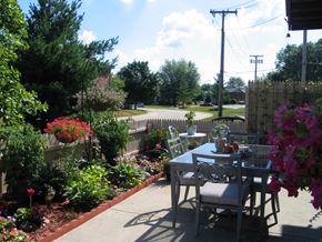 Mishawaka apartment for rent - a patio with a table and chairs in a garden